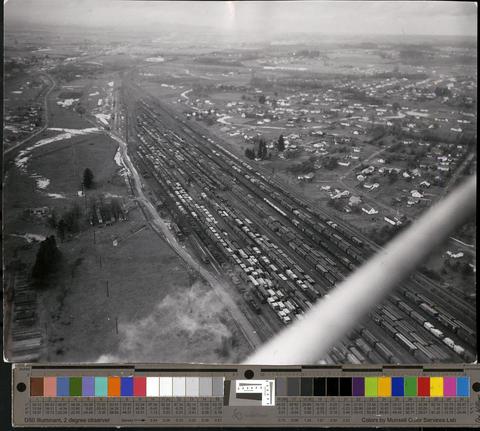 Aerial photo of Eugene area showing train tracks and freight cars., c. 1960s [b001] [174] show page link